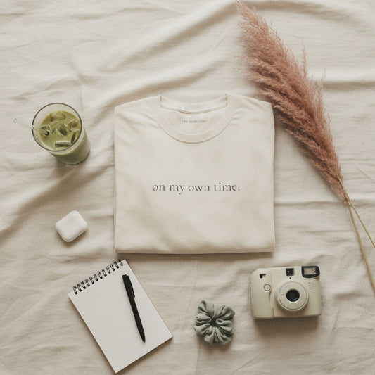 Folded beige t-shirt with text on a white background